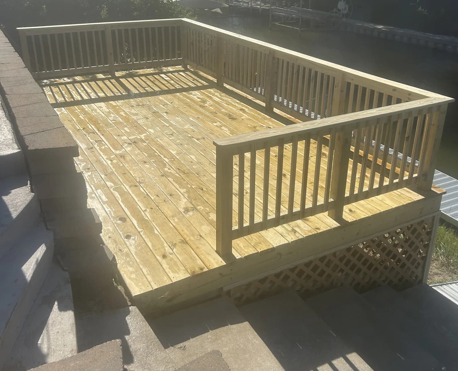 New pressure-treated wood deck with custom railings and wide open floor area