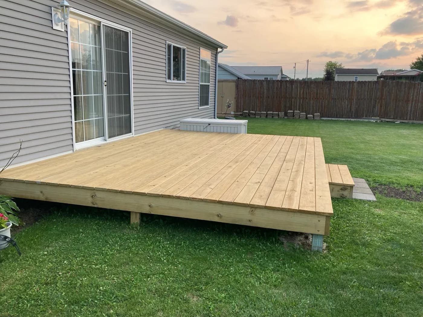 New ground-level pressure-treated deck behind a home