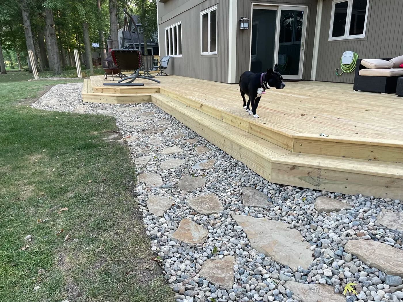Natural wood deck with flagstone walkway and landscaping